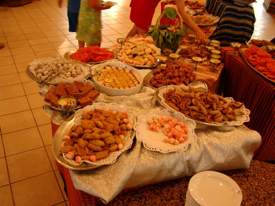 Buffet mit zahlreichen Platten voller Gebäck und kleiner Süßspeisen