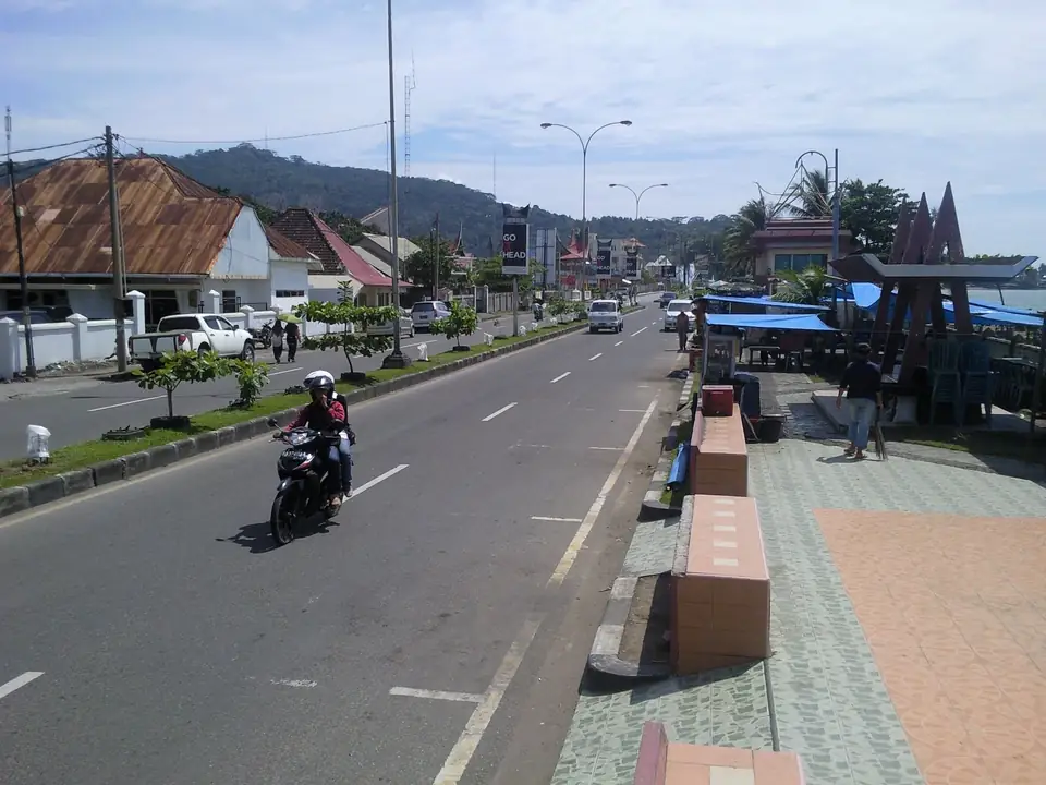 Küstenstraße in Padang mit Palmen und Blick auf das Meer