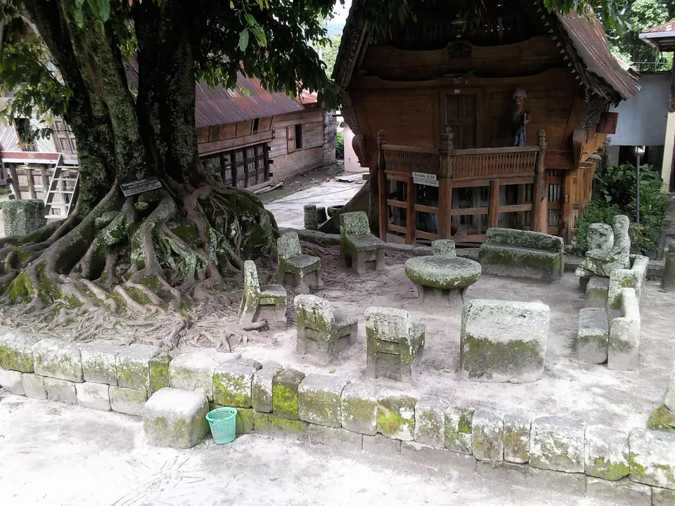 Kreis aus steinernen Stühlen und einem Steintisch unter einem großen Baum