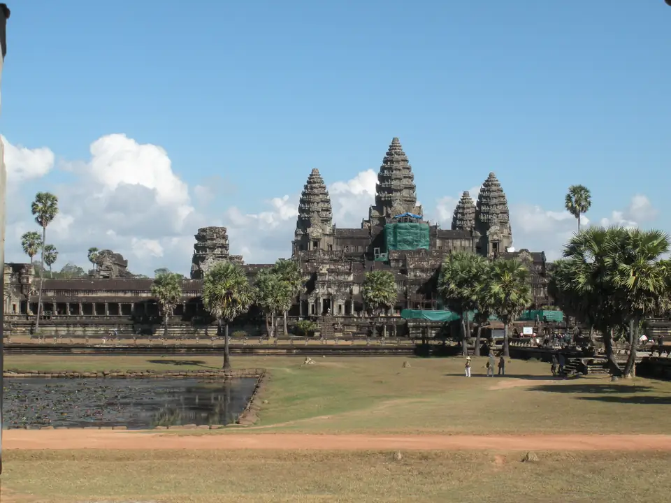 Die zentralen Türme von Angkor Wat über der Grünfläche, teilweise von einem Baugerüst verdeckt