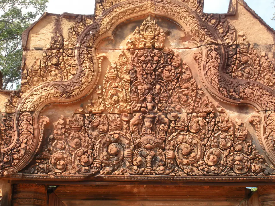 Fein gearbeitete Figuren und Ornamente in einem rötlichen Sandsteingiebel