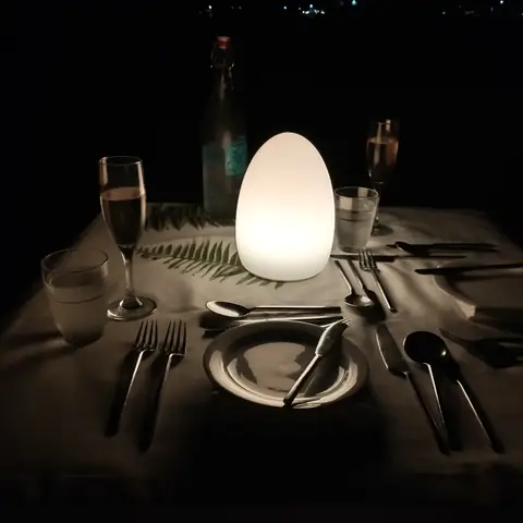 Für zwei Personen gedeckter Tisch beim Stranddinner mit weißer Leuchte und Gläsern