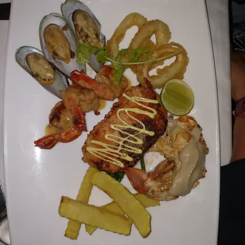 Teller mit Hummer, Fisch, Garnelen, Muscheln, Tintenfischringen und Kartoffelbeilage