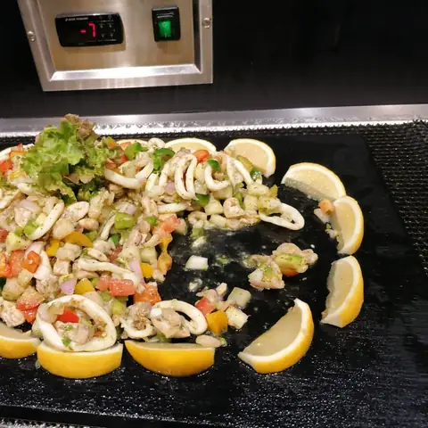 Meeresfrüchtesalat mit Zitronenscheiben am kalten Buffet
