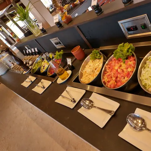 Salatbuffet mit verschiedenen Gemüsesorten, Schüsseln und bereitgelegtem Besteck