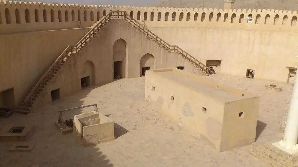 Innenhof des massiven Rundturms mit schmalen Treppen an den hohen Mauern