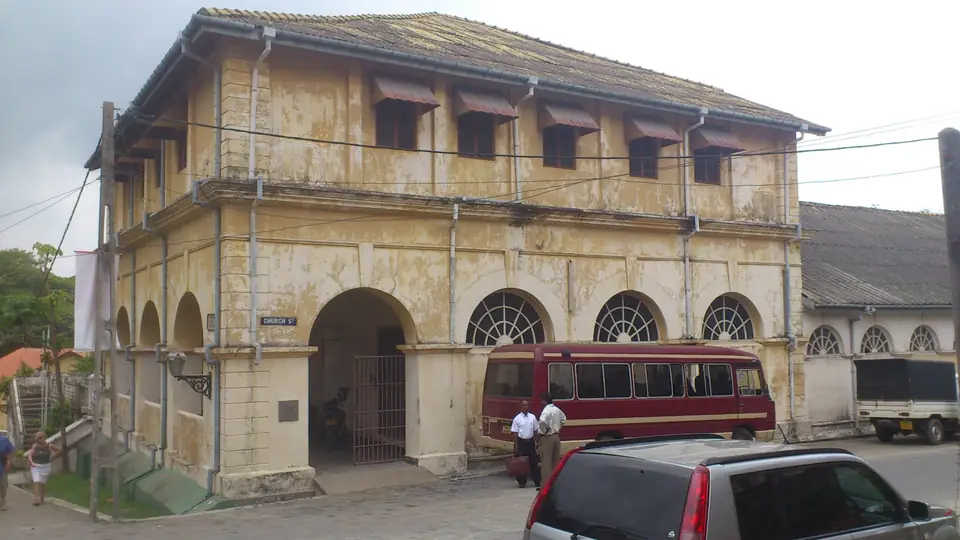 Historisches gelbes Gebäude mit Arkaden an einer Straße in Galle