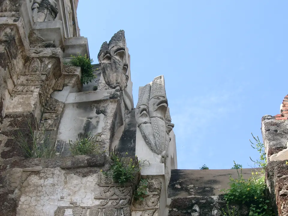 Verwitterte Garudafiguren und Stuckreliefs am Prang des Wat Ratchaburana