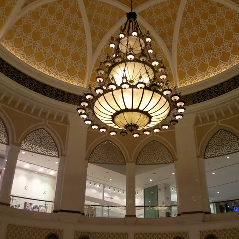 Großer Kronleuchter unter einer goldfarbenen Kuppel mit geometrischen Ornamenten in der Dubai Mall
