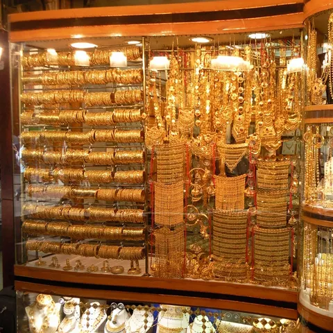 Schaufenster im Deira Gold Souk mit dicht gereihten goldenen Armreifen und langen, aufwendigen Halsketten