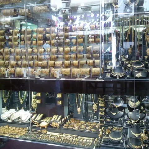 Schmuckauslage im Deira Gold Souk mit goldenen Armreifen, Ringen und Halsketten auf schwarzen Büsten
