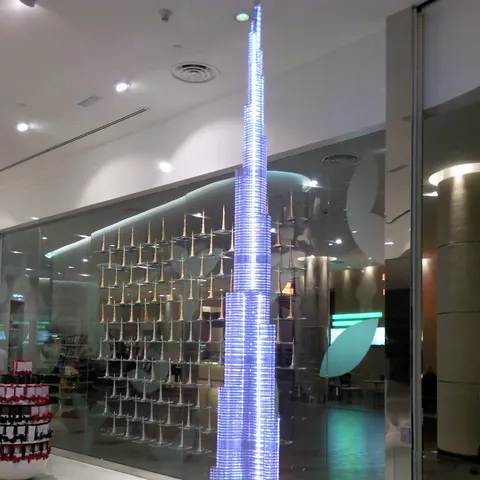 Bläulich beleuchtetes Modell des Burj Khalifa auf einem runden Sockel in einem Innenraum