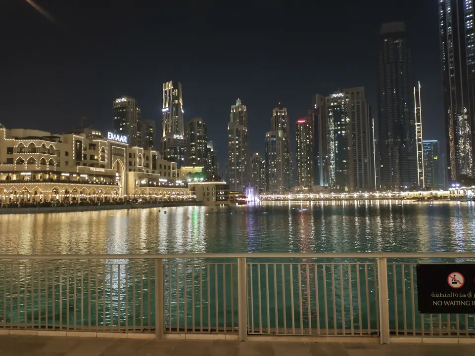 Nächtlicher Blick über den Burj Lake mit beleuchtetem Souk Al Bahar und Hochhäusern am gegenüberliegenden Ufer