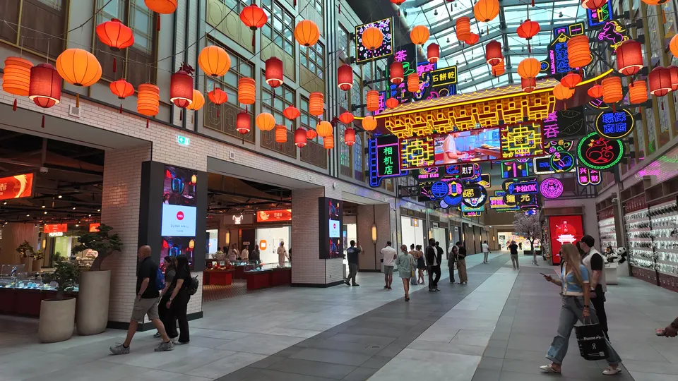 Einkaufspassage in der Dubai Mall mit roten und orangefarbenen Laternen sowie bunten Leuchtschildern mit chinesischen Schriftzeichen