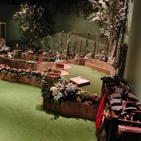 Übersicht über die Minigolfbahnen bei Swingers Dubai mit Rampen, Blumen und einer kleinen Windmühle