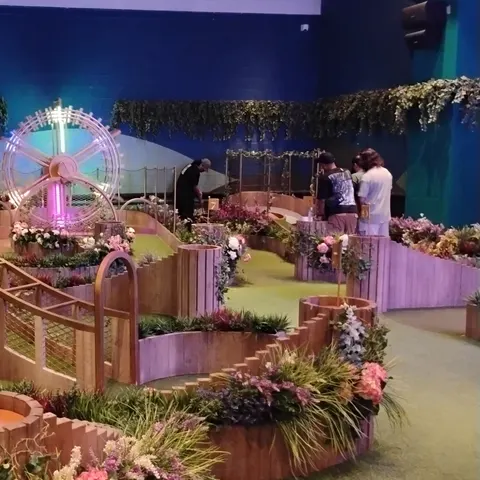 Minigolfbahnen mit kleiner Brücke, Blumenschmuck und einem beleuchteten Rad als Hindernis bei Swingers Dubai