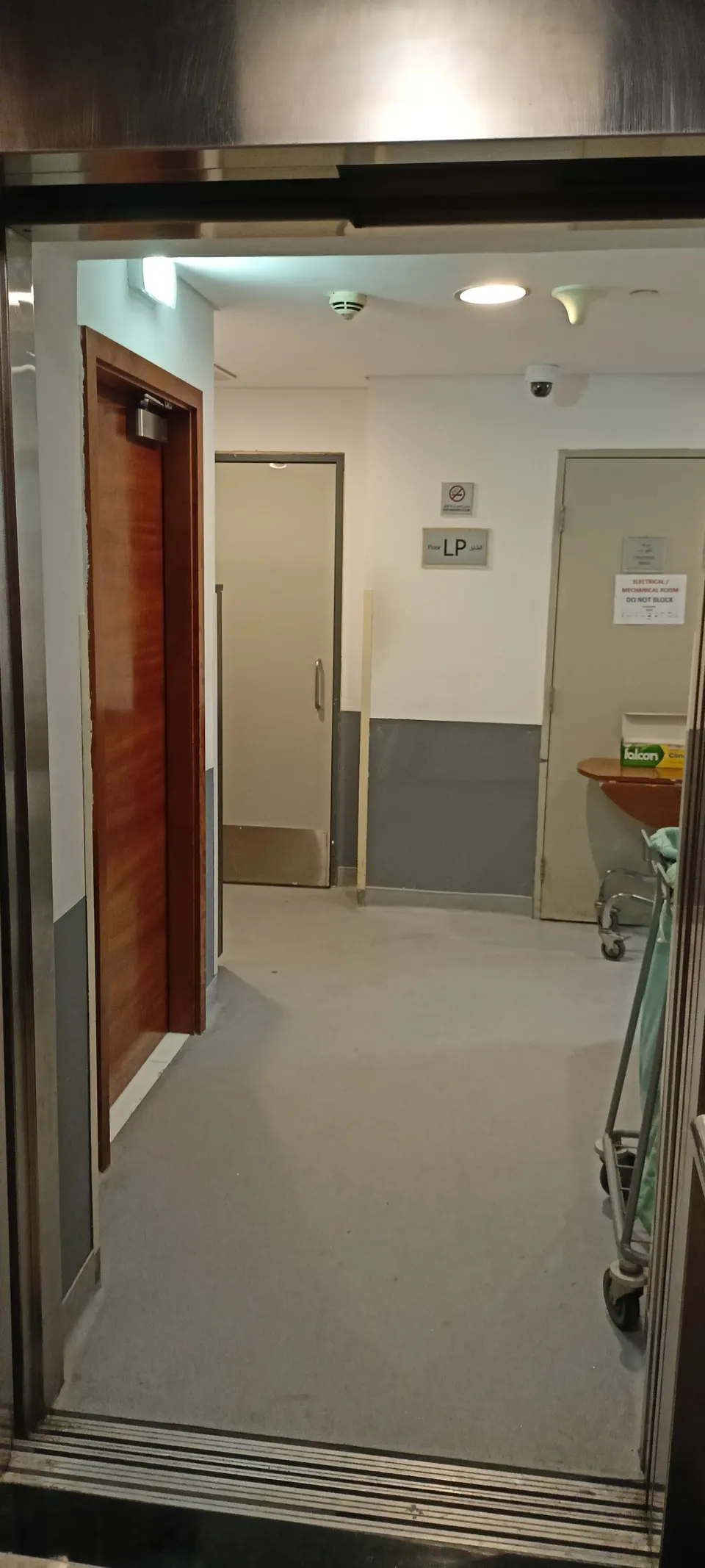 Offene Aufzugstür mit Blick auf einen schmalen Durchgang und eine weitere Tür