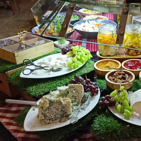 Käseauswahl mit Weintrauben, Crackern und kleinen Schalen auf einer Buffetstation
