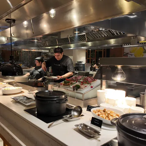 Köche an der offenen Kochstation des Abendbuffets im Grosvenor House mit warmen Speisen und ausgelegtem Fleisch