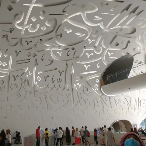 Arabische Schriftzeichen an der weißen Decke und den Wänden der mehrgeschossigen Eingangshalle