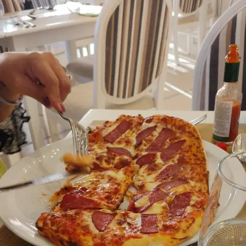 Pizza auf einem weißen Teller im Hotelrestaurant