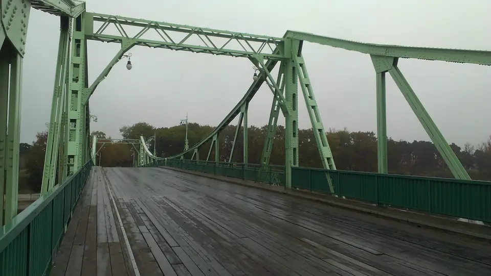 Grüne Stahlträger und hölzerne Fahrbahn der Brücke über den Karosta-Kanal