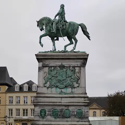 Bronzenes Reiterstandbild auf einem hohen Steinsockel mit Wappenrelief