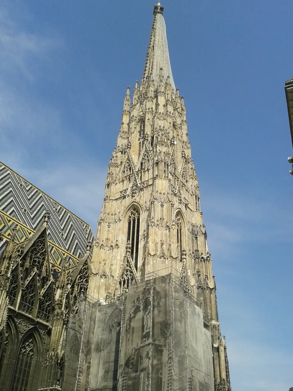 Hoher gotischer Kirchturm mit steinernen Maßwerkspitzen