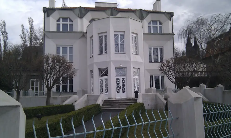 Helle Villa mit kantig vorspringender Gartenfassade, geometrischer Freitreppe und kubistisch gestaltetem Zaun