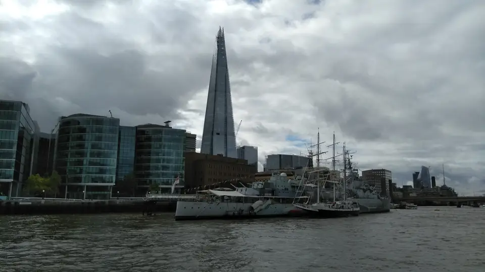 Graues Museumsschiff HMS Belfast auf der Themse mit dem gläsernen Hochhaus The Shard dahinter