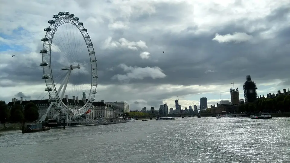 London Eye mit seinen gläsernen Kapseln am Themseufer neben der Fassade der County Hall