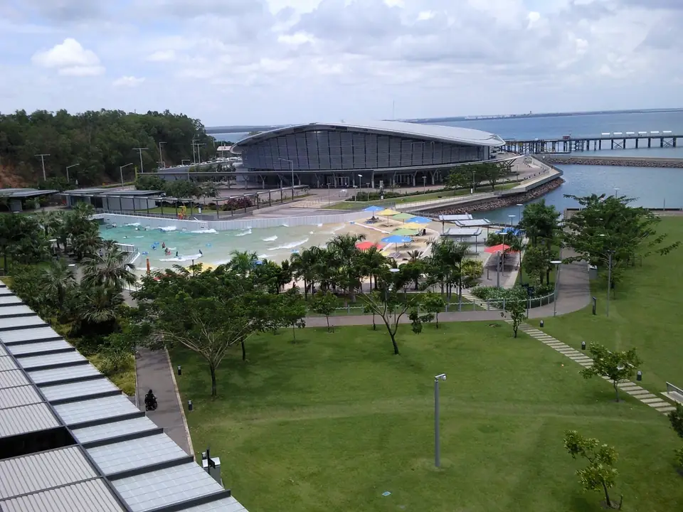 Wellenbad mit Badegästen und Sonnenschirmen vor dem Darwin Convention Centre