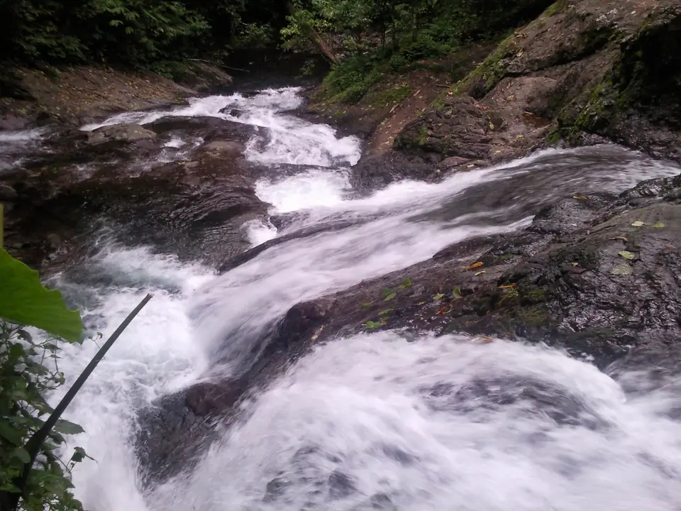 Wasser fließt über mehrere glatte schräge Felsflächen bei den Papase’ea Sliding Rocks