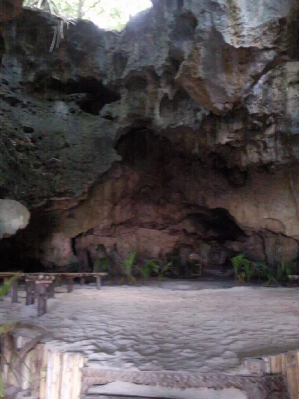Hohe offene Felsenhalle der Hina Cave mit Sandboden und Tageslicht von oben